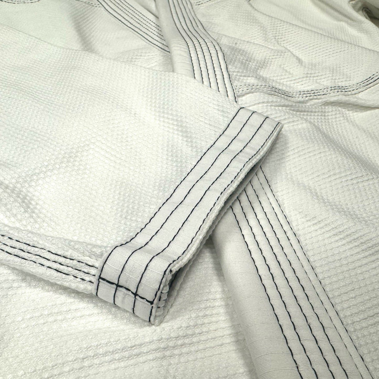 Zed Honra Women’s Alpha Gi – Close-Up of White BJJ Kimono Sleeve with Reinforced Stitching