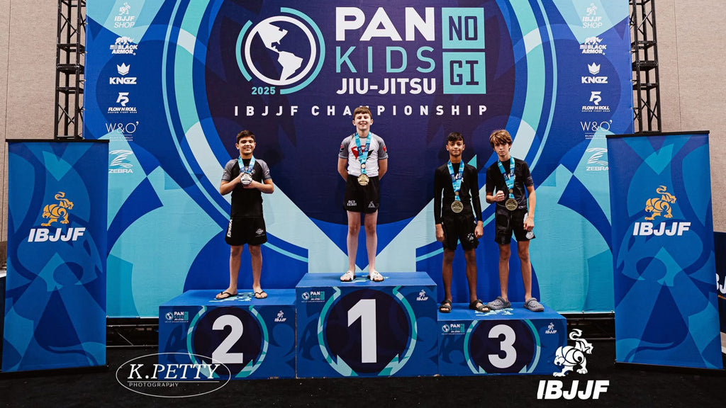 Zachary Helka stands on the first-place podium after winning gold at the 2025 IBJJF No-Gi PAN Kids Championship, surrounded by fellow medalists.