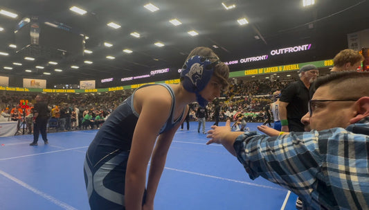 Zachary Helka receives coaching during a match at the 2025 MMWA State Wrestling Finals