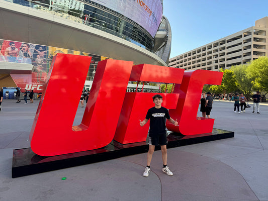 Zachary Helka standing in front of the UFC sign at T-Mobile Arena in Las Vegas during the 2024 IBJJF Nationals trip.